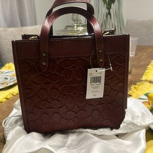 Signature leather field tote with shoulder strap and Coach bag to store it in